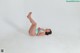 A woman in a blue bathing suit laying on the ground.